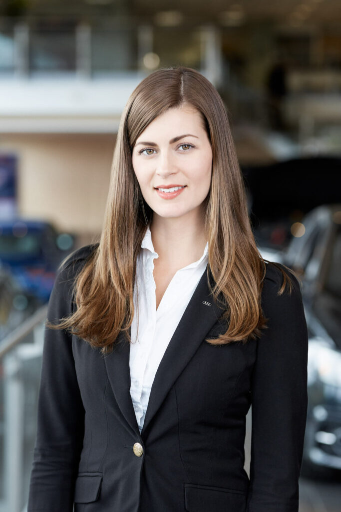 Corporate headshot of a caucasian woman in business attire in an office environment.