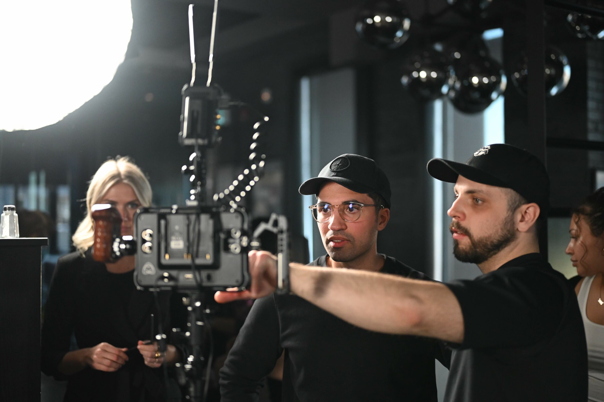 Lapse Productions Producer and Cinematographer Collaborating, Pointing at a Field Monitor on Set.