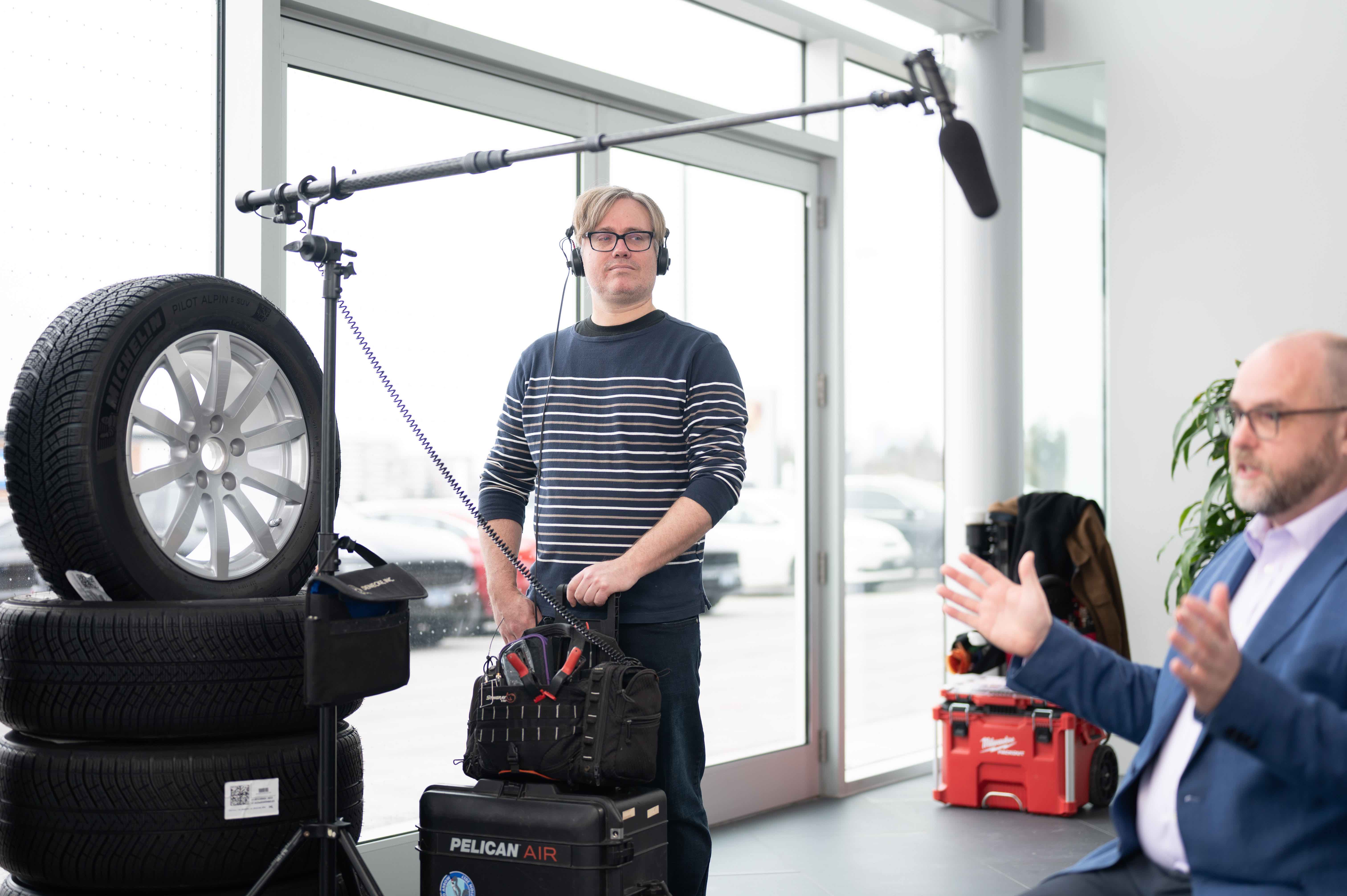 Audio Operator from Lapse Productions Monitoring Sound Equipment During an Interview at a Car Dealership