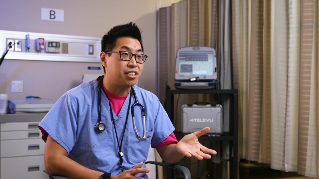 A doctor in the middle of a dynamic gesture, demonstrating the engagement pose during a video shoot.