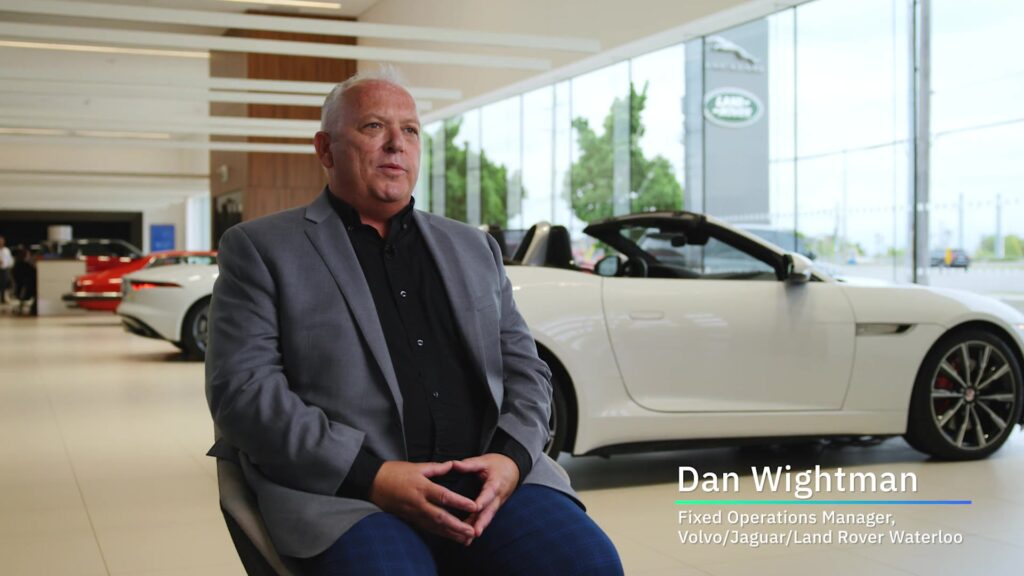 Owner of a car dealership (Volvo, Jaguar, Land Rover) seated in a power pose, exuding authority.  