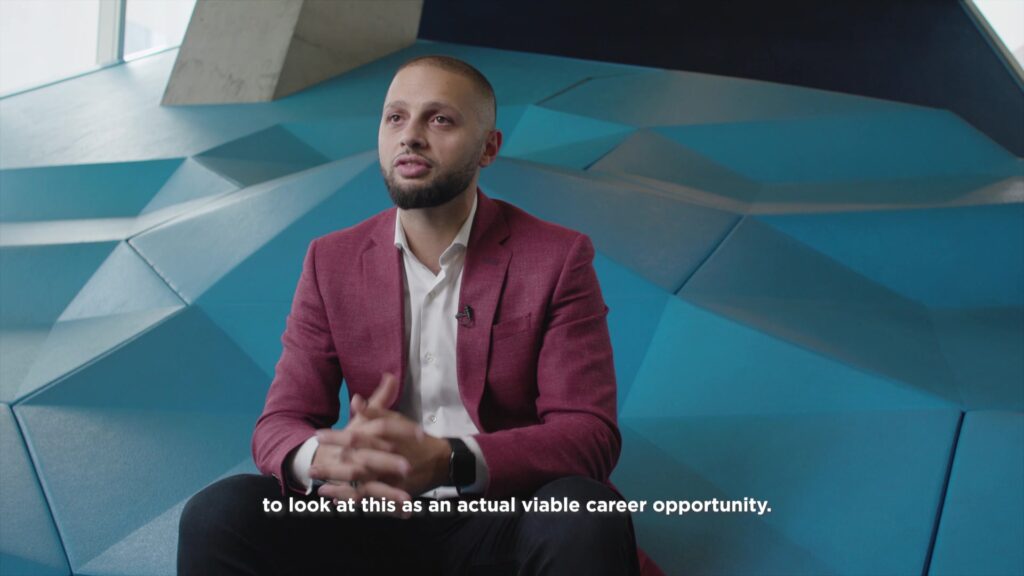 Business professional in a relaxed pose during a corporate interview, sitting comfortably with crossed fingers, promoting an open conversation.